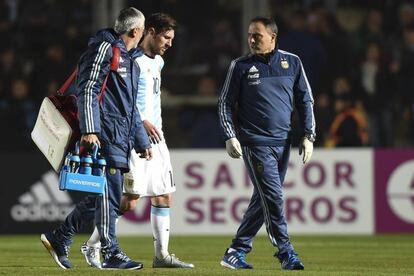 Messi sale del campo junto con los médicos de la selección argentina.