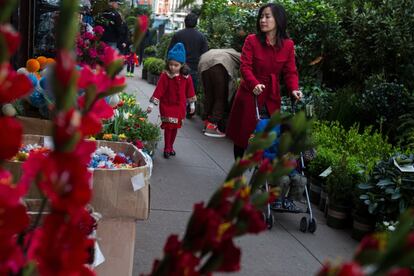 Pedestrians walk past plants displayed for sale in Manhattan's flower district in New York, U.S., on Thursday, March 24, 2016. With an El Nino in the equatorial Pacific, winter across the contiguous U.S. was the warmest in history, and new daily high temperatures were posted last week in Philadelphia, Trenton, Boston and New York's Central Park. Photographer: Michael Nagle/Bloomberg