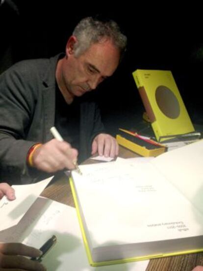 Ferran Adrià firma un ejemplar de su "enciclopedia" de recetas de cocina en China.