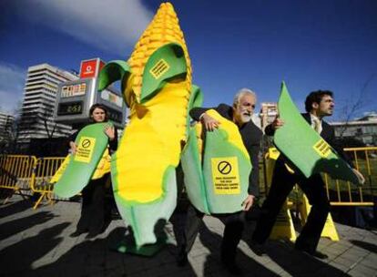 Miembros de la ONG Intermón Oxfam trocean una gran mazorca de maíz en una protesta a las puertas de la reunión de la ONU en Madrid.