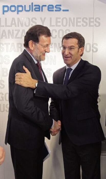 PP leader and prime minister, Mariano Rajoy (l), congratulates Galician premier Alberto N&uacute;&ntilde;ez Feij&oacute;o after the latter&#039;s re-election. 