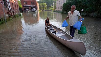 Two residents of Montpelier, Vermont, on July 11, following storms that ravaged the northeastern U.S. state in an episode that experts linked to climate change.