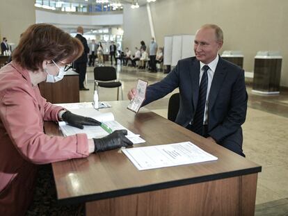 Putin mostra seu passaporte antes de votar, nesta quarta-feira, em uma seção eleitoral de Moscou.