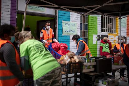 Los voluntarios reparten comida este sábado en la Asociación de Vecinos de Aluche. 
