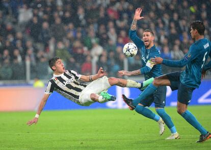 El jugador de la Juventus Paulo Dybala cae ante Raphael Varane y Sergio Ramos.