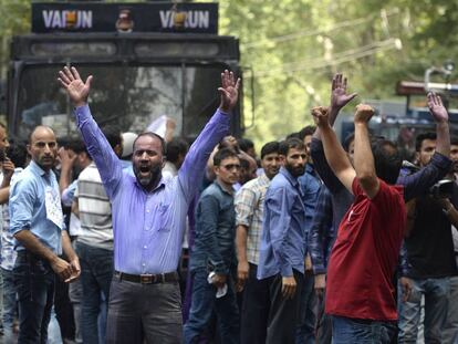 TOPSHOT - Kashmiri government teachers shout anti government slogans as Indian police spray purple coloured water during a protest in Srinagar on July 17, 2018.  Dozens of government employees were detained as they demanded hikes in salary and regularisations of their job. / AFP PHOTO / TAUSEEF MUSTAFA