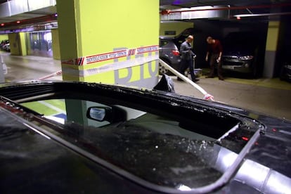 Agentes de los Mossos buscan pruebas en el aparcamiento de la estación de Sants.En primer plano, el cristal del techo roto del coche que presuntamente robó el fallecido.