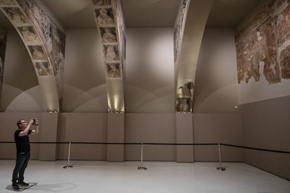 Un visitante fotografía un fragmento de las pinturas románicas de Sijena, este martes en el MNAC.