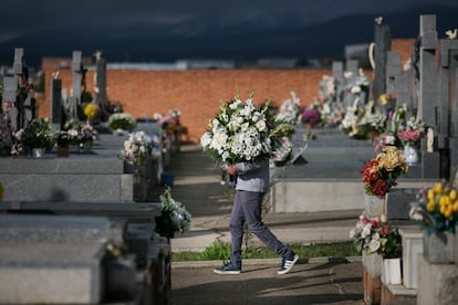 Un hombre sujeta un ramo de flores en el cementerio de Colmenar Viejo, en Madrid. 