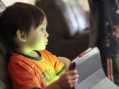 Un niño juega con una tableta.