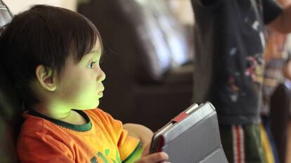 Un niño juega con una tableta.