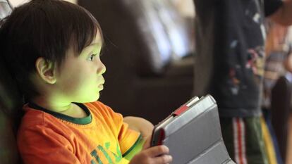 Un niño juega con una tableta.