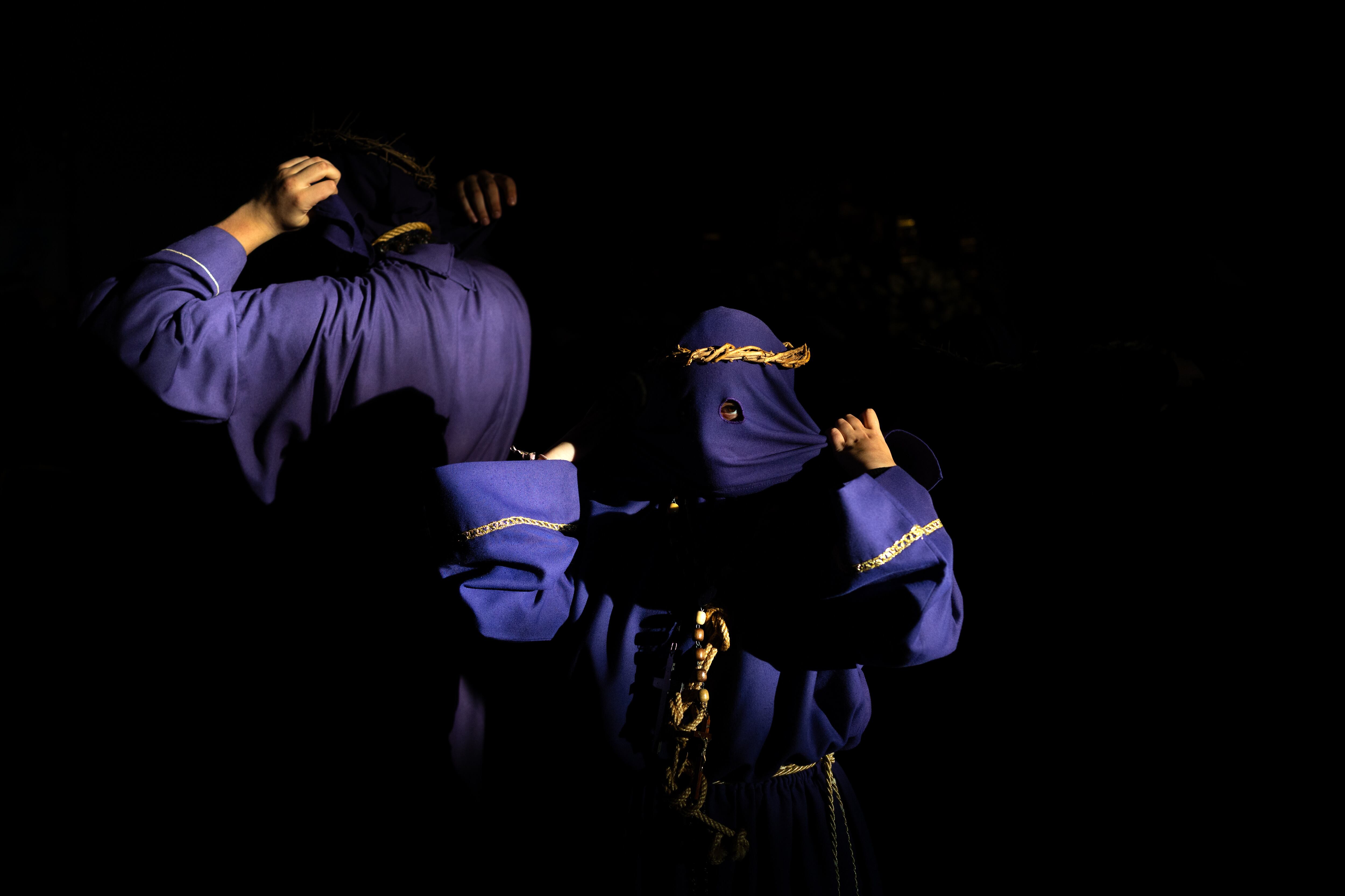 Dos penitentes de la hermandad de Jesús Nazareno se colocan las capuchas.