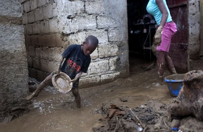 Un niño colabora en la limpieza de su casa, tras el paso de Isaac, en Puerto Príncipe.