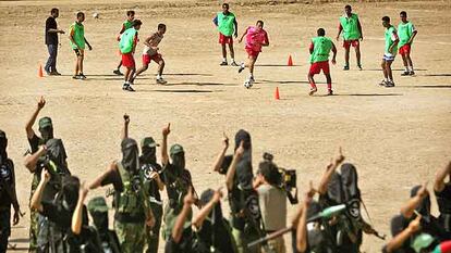 Los jugadores de Palestina se entrenan en Gaza. En primer plano, un grupo de milicianos.