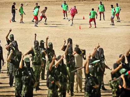 Los jugadores de Palestina se entrenan en Gaza. En primer plano, un grupo de milicianos.