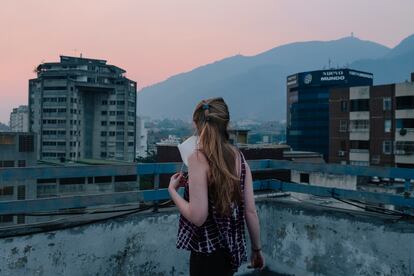 Una mujer observa el atardecer en una azotea del barrio de Chacao en Caracas, al inicio de la cuarentena, el 18 de abril.