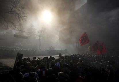 Os manifestantes lançaram coquetéis molotov, artefatos pirotécnicos e pedras contra as forças de segurança. Na imagem, membros da polícia (e) enfrentam os manifestantes no centro de Kiev (Ucrânia) na terça-feira.