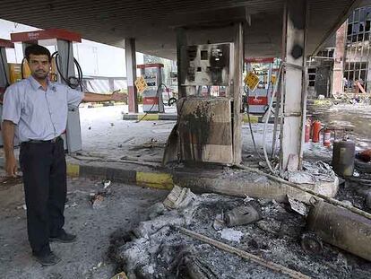 Un hombre muestra los daños causados durante las protestas contra el racionamiento de combustible en una gasolinera de Teherán.