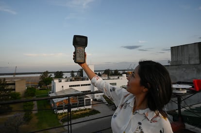 Adriana Ipiña sostiene un medidor PM2.5 (material particulado) indicador de la calidad del aire.