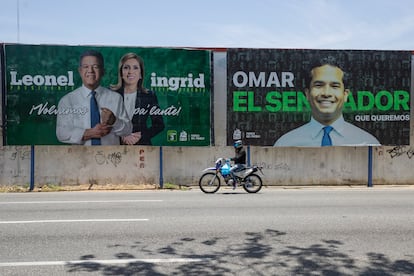 Un motociclista pasa frente a un cartel de campaña electoral del tres veces presidente, Leonel Fernández, en Santo Domingo, el 12 de mayo.