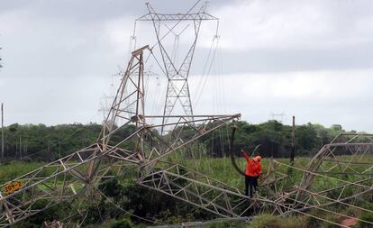Técnicos reparam rede de transmissão atingida por bomba na periferia de Fortaleza.