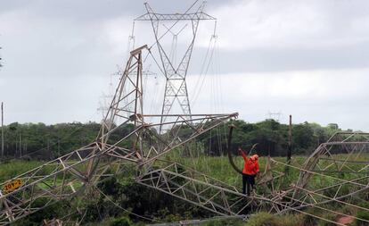 Técnicos reparam rede de transmissão atingida por bomba na periferia de Fortaleza. 