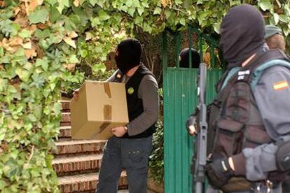 Dos agentes de la la Guardia Civil concluyen el registro de un taller en el barrio granadino de la Cartuja incautándose de diverso material.