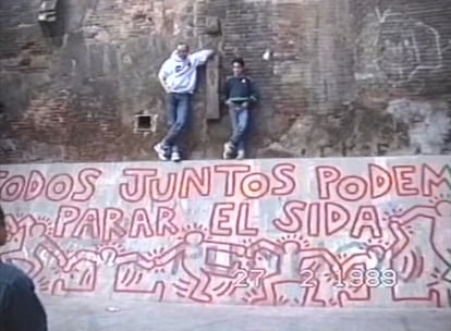 Fotograma del vídeo en el que César de Melero inmortalizó la visita de Keith Haring a Barcelona. En la imagen, el artista posa junto a David sobre el mural ya terminado. |