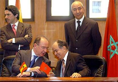 Rato y el ministro marroquí de Hacienda, Fatallah Ualalu, firman los acuerdos económicos en presencia de Aznar y Jettu.