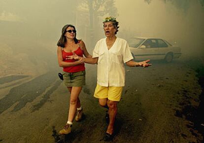 Una mujer grita "?dnde estn los bomberos?" mientras que otra la dirige fuera de la urbanizacin donde viven, rodeada de humo y fuego en Moonpark (California).