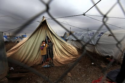 Alaa Ahmed, de oito anos, toma chá ao lado de seu irmão na entrada da tenda de sua família em Dohuk, Iraque (2013). A piora do inverno dificultava a vida diária das crianças e famílias sírias no campo de refugiados de Domiz, no norte do Iraque. Segundo o Acnur, mais de 40.000 refugiados sírios estavam registrados nesse acampamento, o dobro da capacidade para a qual ele foi criado.