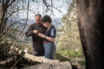 El cocinero David Pérez y la investigadora Ana Belén Marín, en la cueva de Covalanas, examinando huesos y semillas halladas en las cuevas rupestres.