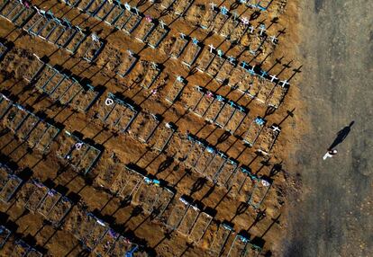 Un hombre caminando junto a las tumbas del cementerio Nossa Senhora Aparecida en Manaos (Brasil).