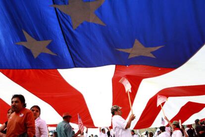 Trabajadores latinos procedentes del Estado de Florida sostienen una bandera estadounidense gigante durante la marcha en Washington.