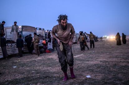 Un sospechoso de pertenecer al Estado Islámico (ISIS, en sus siglas inglesas) pasa ante miembros de las milicias kurdas de las Fuerzas Democráticas Sirias (SDF) inmediatamente después de salir de Baghuz, el pasado 4 de marzo.