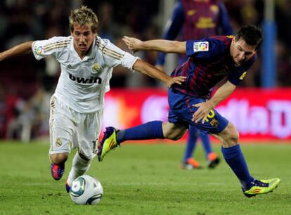 Coentrão se lleva un balón ante Messi durante el partido de vuelta de la final de la Supercopa.