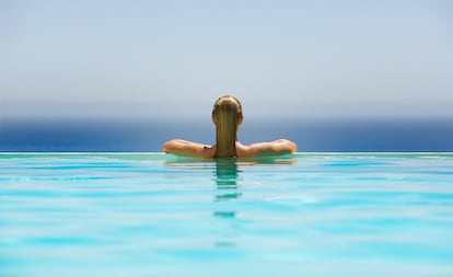 Una turista contempla el mar desde la piscina infinita de un hotel.
