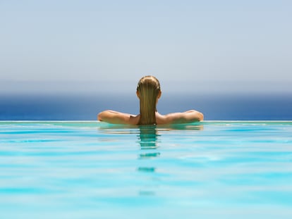 Una turista contempla el mar desde la piscina infinita de un hotel.