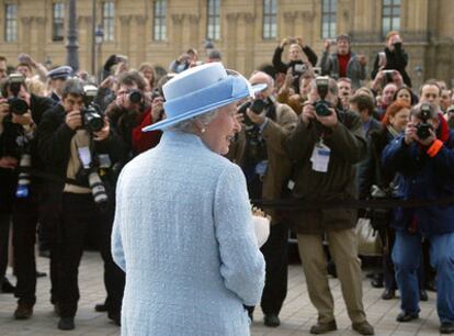 La reina Isabel II de Inglaterra, acosada por una nube de fotógrafos.