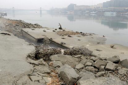 El bajo nivel del agua del río Danubio deja ver partes de la orilla bajo el puente Libertad de Budapest, Hungría, hoy, domingo, 4 de diciembre de 2011.