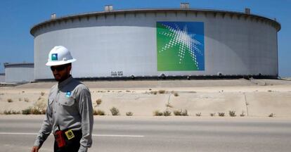Empleado de Aramco ante un tanque de petróleo.
