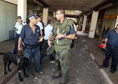 Miembros de las fuerzas de seguridad israelíes inspeccionan la zona de la explosión.