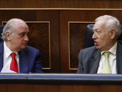 El ministro del Interior conversa con el ministro de Asuntos Exteriores durante la sesión de control al Gobierno.
