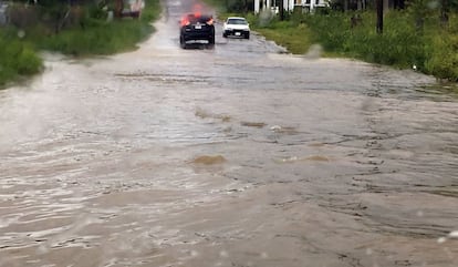 Dos vehículos encuentran el paso bloqueado debido a las inundaciones en una carretera de San Juan, en Antigua y Barbuda. 