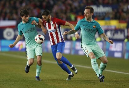 El centrocampista belga del Atlético de Madrid Yannick Ferreira-Carrasco (centro) es presionado por los jugadores del Barcelona.