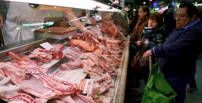 Varias personas esperan su turno en una carnicería del Mercado de Maravillas, en Madrid.