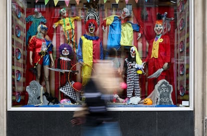 Una persona pasa por delante de un escaparate con disfraces de Halloween en Madrid.