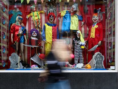 Una persona pasa por delante de un escaparate con disfraces de Halloween en Madrid.