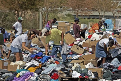 Varios damnificados por el paso del huracán rebuscan ropa entre cajas de ayuda en la zona de Gulfport, Misisipi.